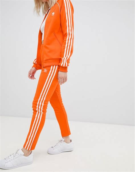 grijze adidas broek met oranje logo|Adidas sportbroeken.